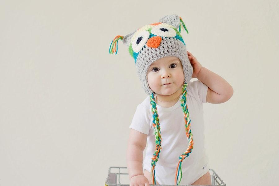 Cute baby standing in white bodysuit