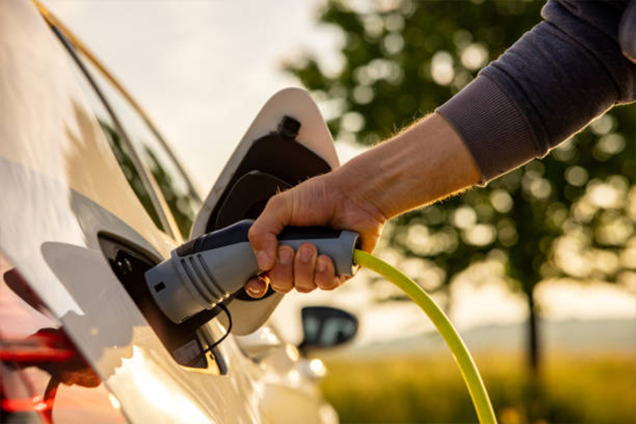 Electric car being plugged in to charge by the owner