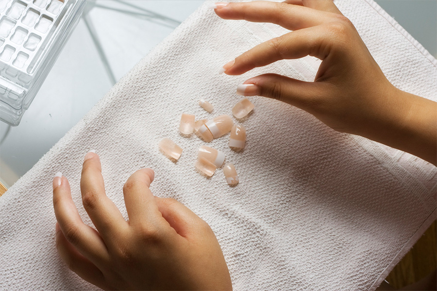 Hands of a person applying press-on nails