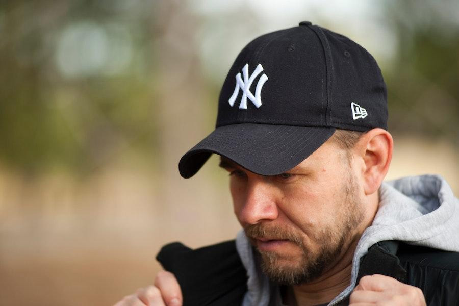 Man posing in a black 5-panel baseball cap