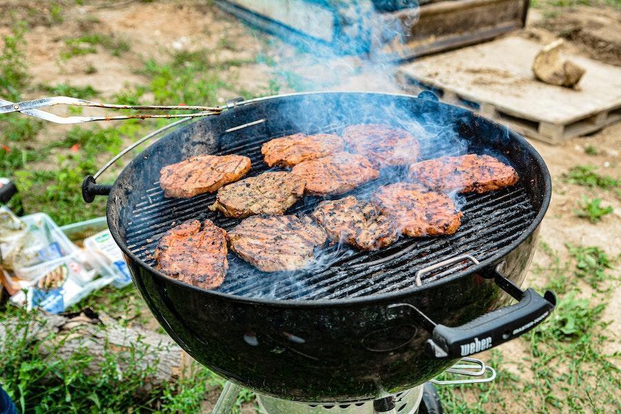 Meat cooking on barrel charcoal grill