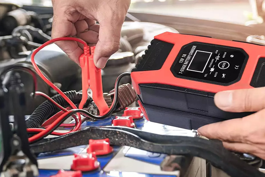 Motorcycle being charged using a red battery charger