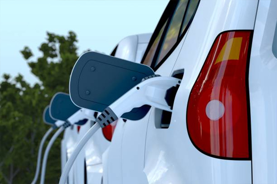 Three white electric cars lined up at charging station