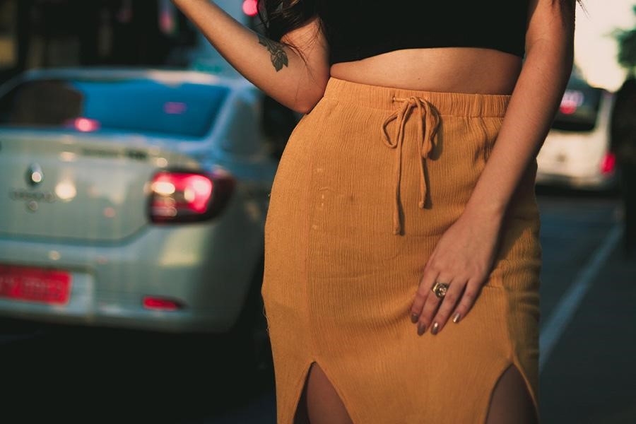 Woman standing near cars with a double-slit column skirt