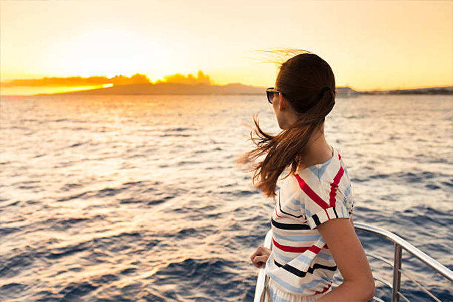 Woman wearing a striped T-shirt at sunset on boat