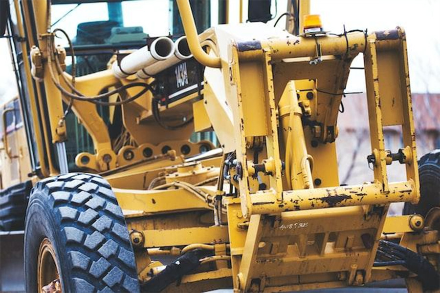 A large yellow bulldozer on a city street