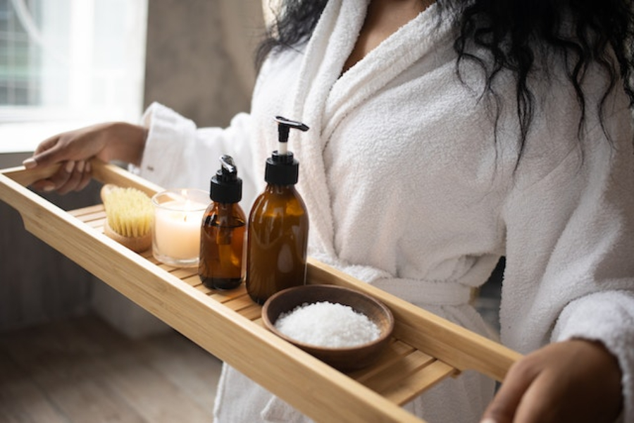 A woman carrying a tray of bath essentials