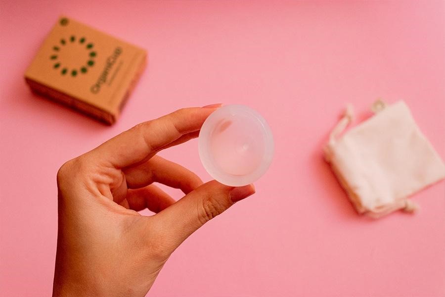 A woman holding a menstrual cup