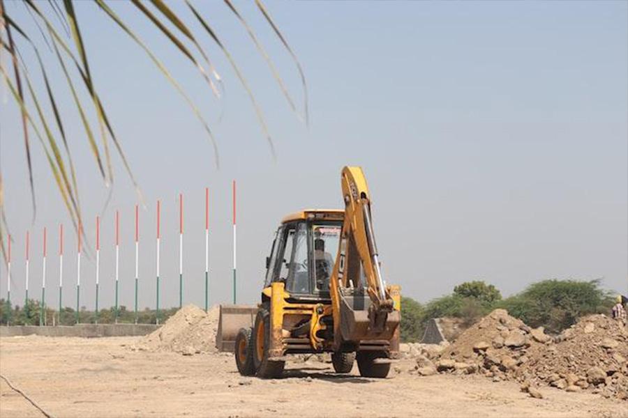 Backhoe machine being used to move debris