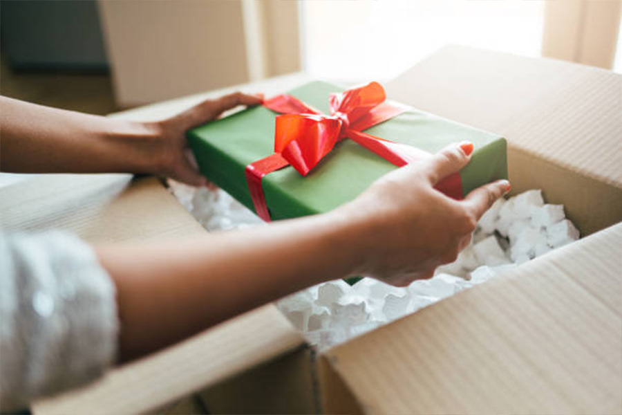 Christmas present wrapped in green paper with red bow