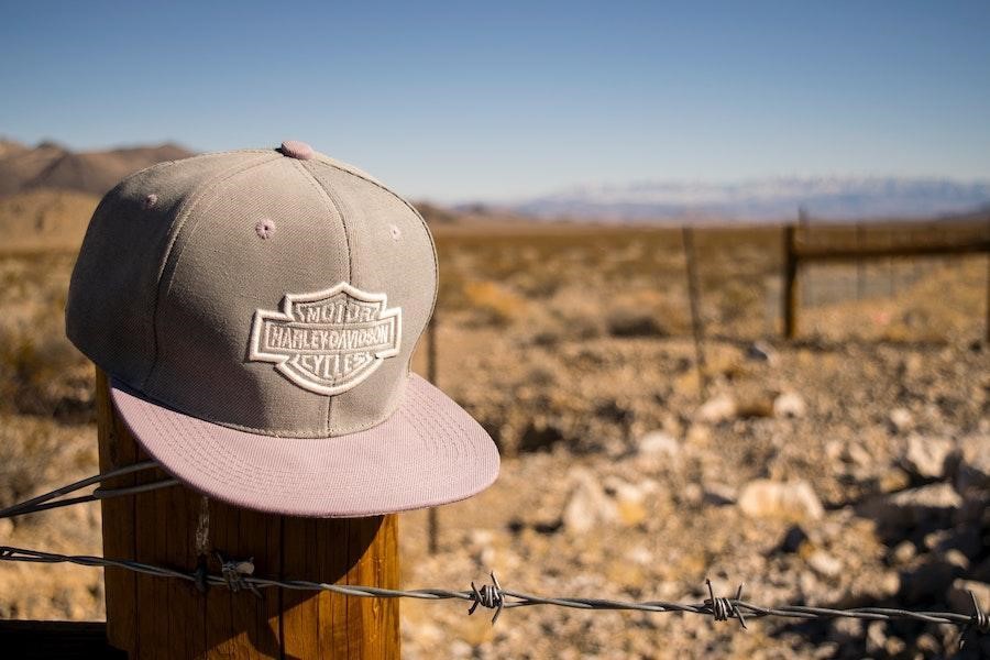 Embroidery snapback handing on a wooden pole