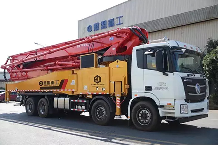 Foton concrete pump truck parked near an office