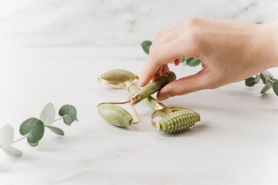 Green and gold face roller beauty tools