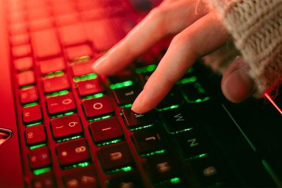 Lady typing on a keyboard with green backlighting