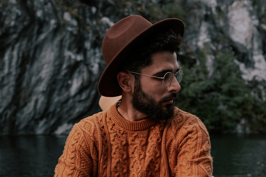 Man in a brown boater-style hat at a lake