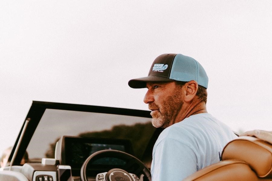 Man in a car wearing a two-toned baseball cap