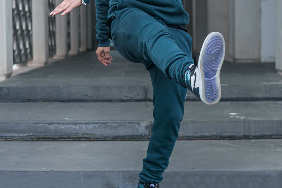 man kicking in green joggers