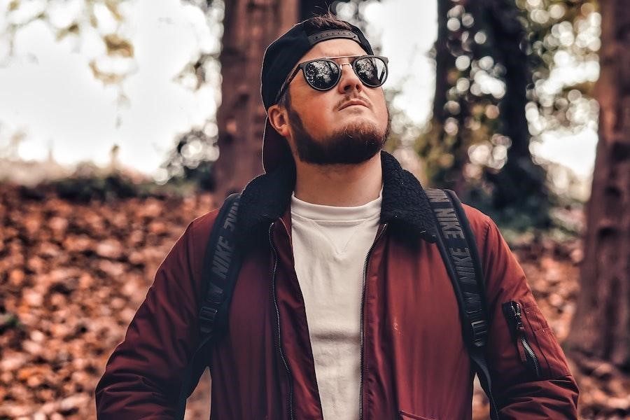 Man posing in a forest with a snapback hat