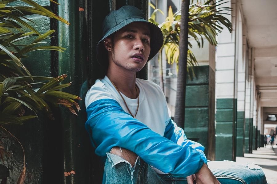 Man posing in dark denim bucket hat