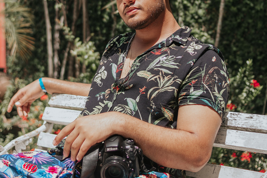 man sitting on a bench in a black resort shirt