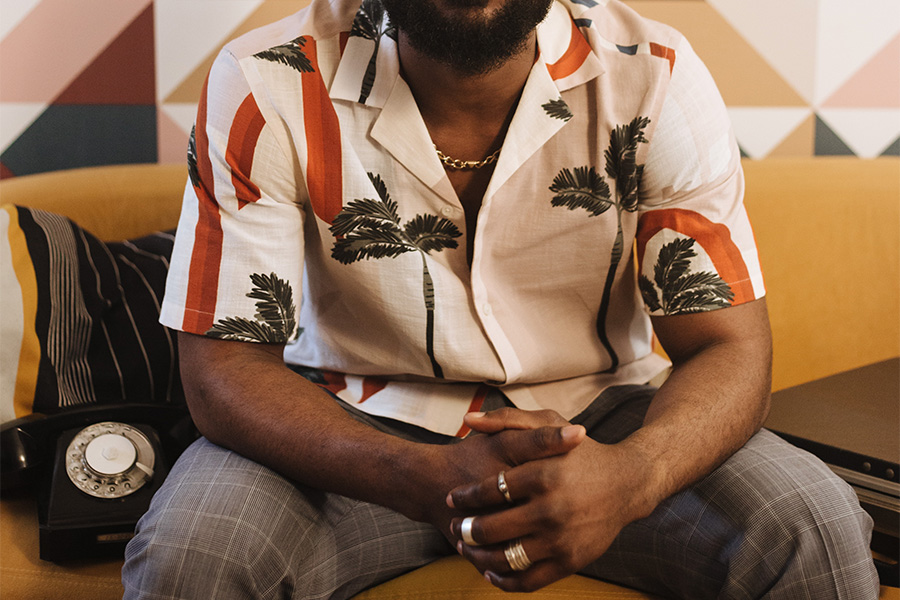 man sitting on a couch in a resort shirt