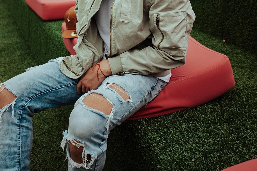 Man sitting on a red seat in grunge jeans