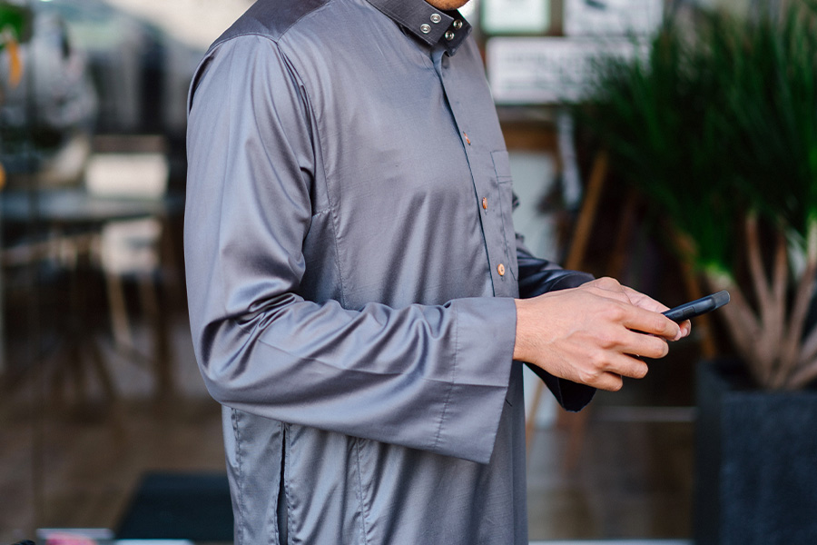 man wearing a tunic while operating a phone