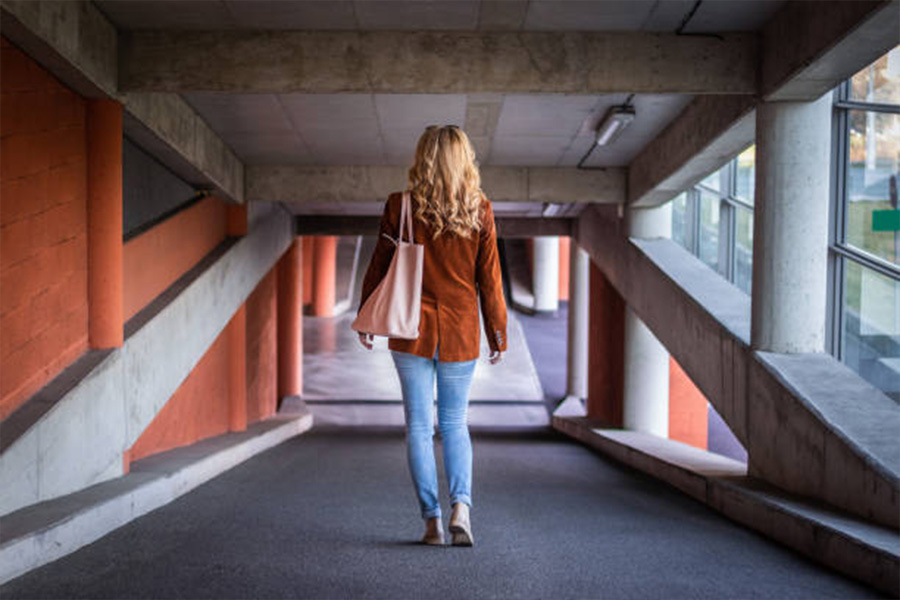 Woman in jeans and brown corduroy jacket in parking garage