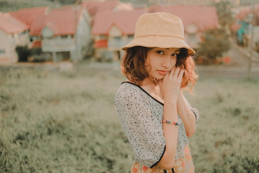 Woman posing in a cream bucket hat