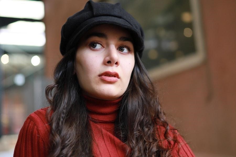 Woman rocking a black schoolboy hat