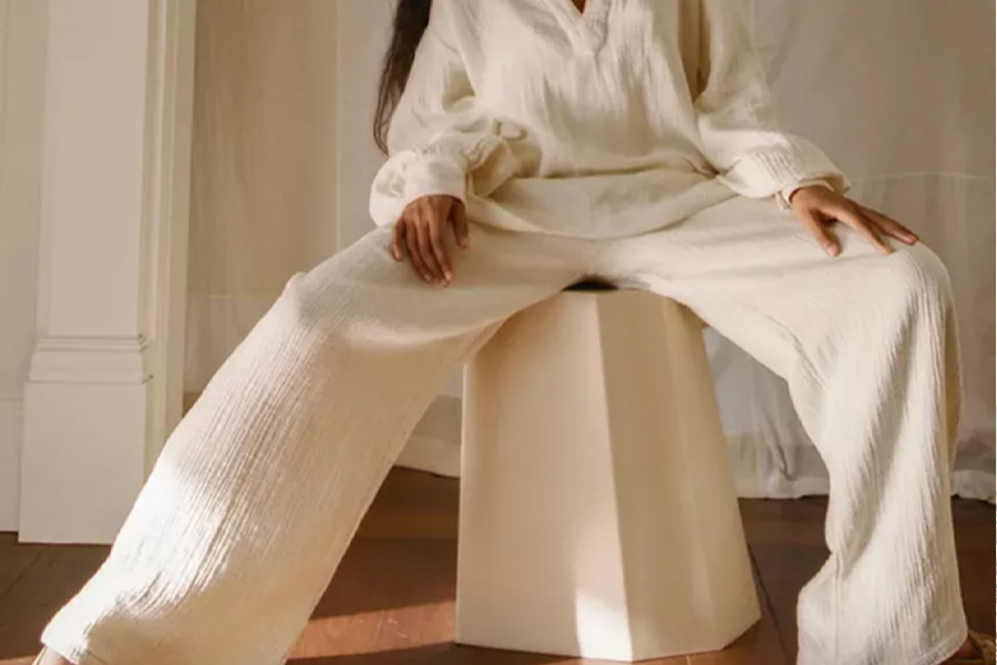 Woman sitting in cream colored woven set indoors