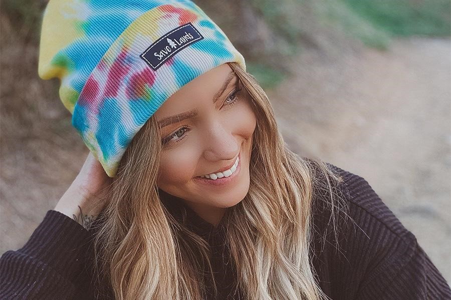 Woman striking a pose while wearing a tie-dye beanie