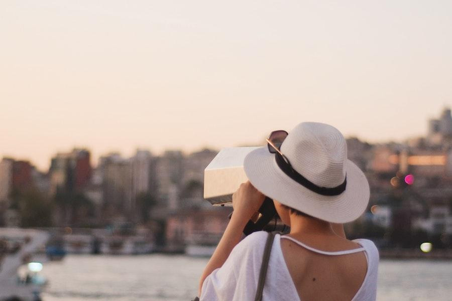 Woman taking pictures in a panama straw hat