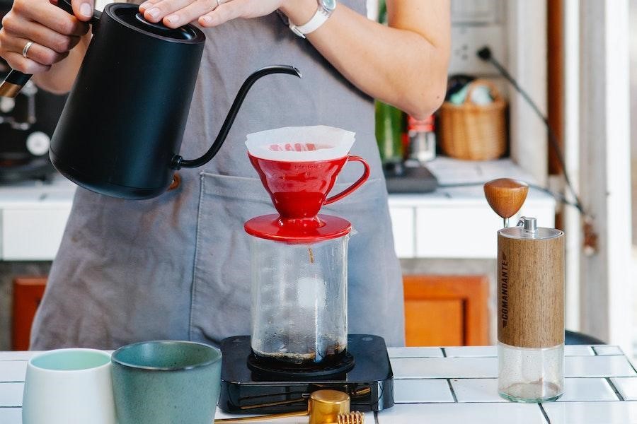 Barista pouring water into a drip coffee machine