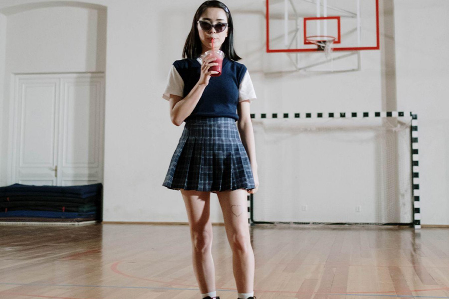 Girl in traditional uniform-like pleated skirt and vest