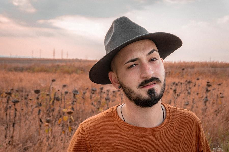 Man in an orange top wearing a felt hat