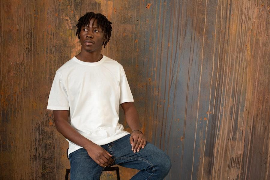 Man looking sideways in a white shirt and jeans outfit