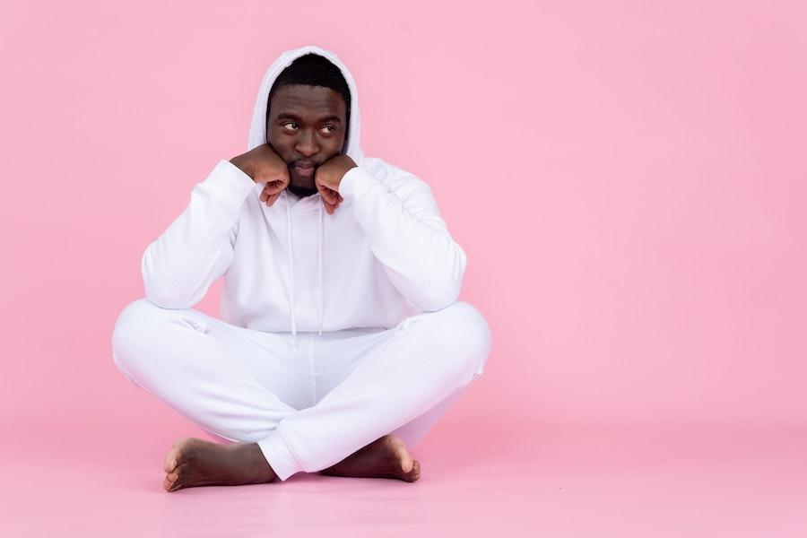 Man posing in a white sweatshirt and joggers combo