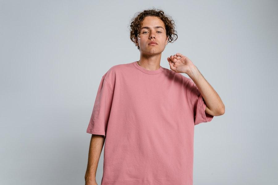 Man posing while rocking a pink boxy tee