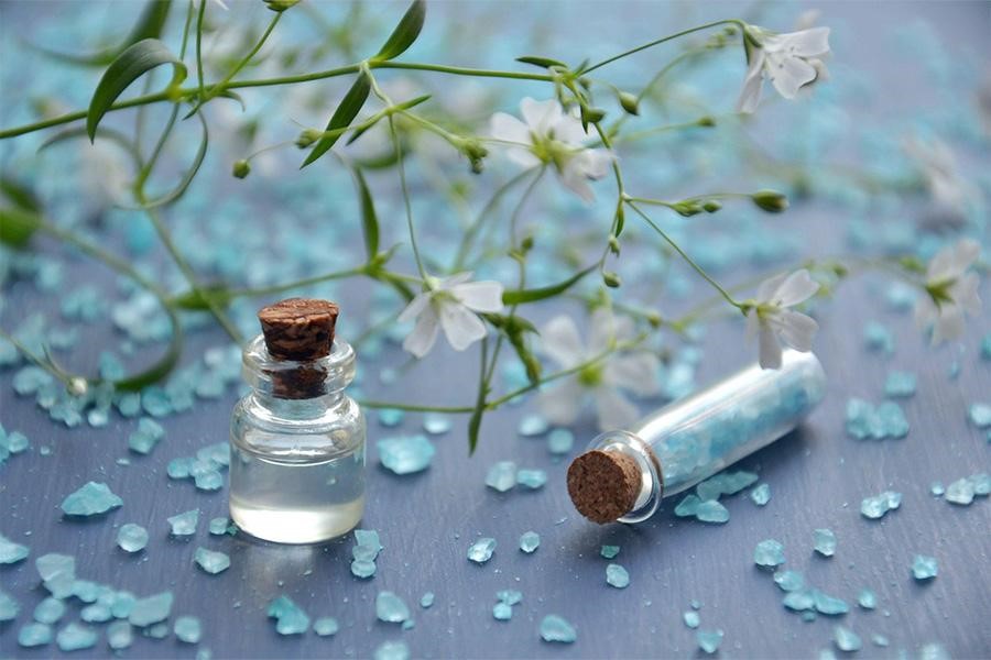 Perfume surrounded by light-blue crystals