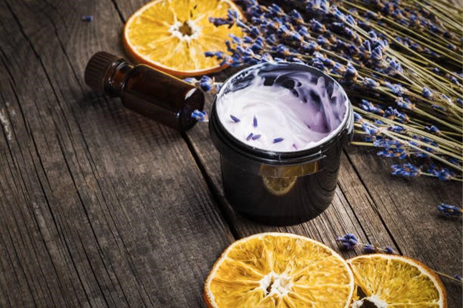 Small jar of lavender cream next to empty oil vial