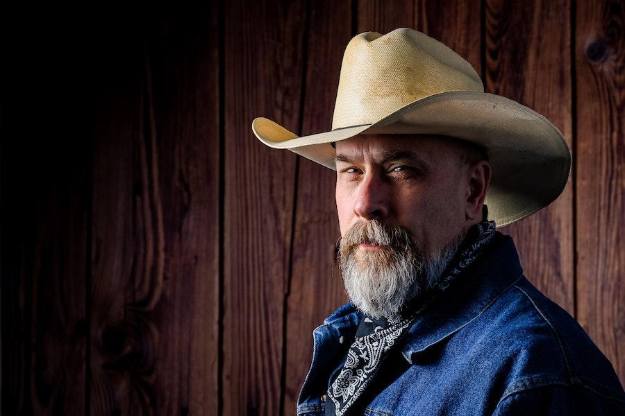 White bearded man wearing a cream cowboy hat