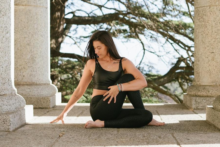 Woman posing in a black cropped tank and leggings