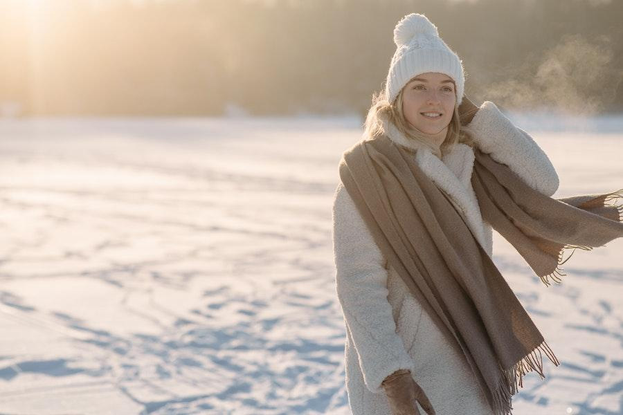 Woman posing in a white pom-pom beanie