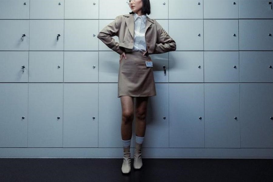 Woman posing while wearing a brown office attire