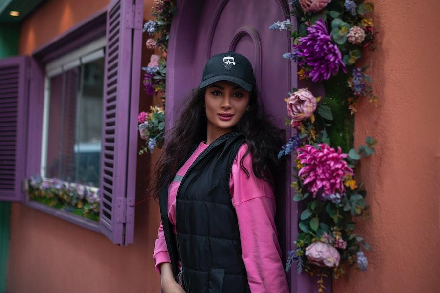 Woman posing with a black baseball cap