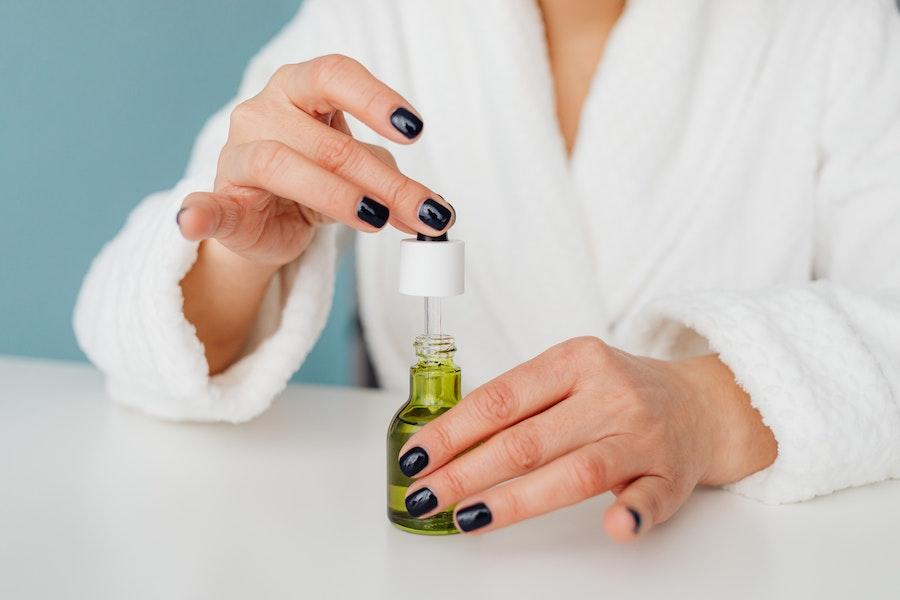 Woman preparing to use body oil