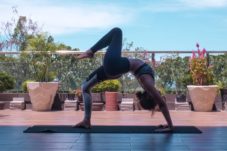 Woman Standing and Holding Blue Yoga Mat