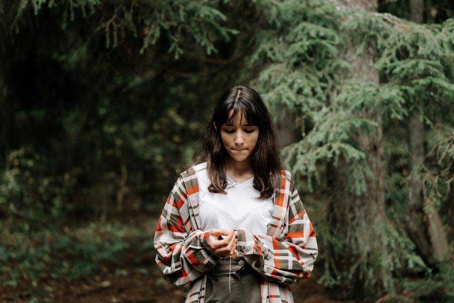 Woman wearing a colorful plaid jacket over a white tee