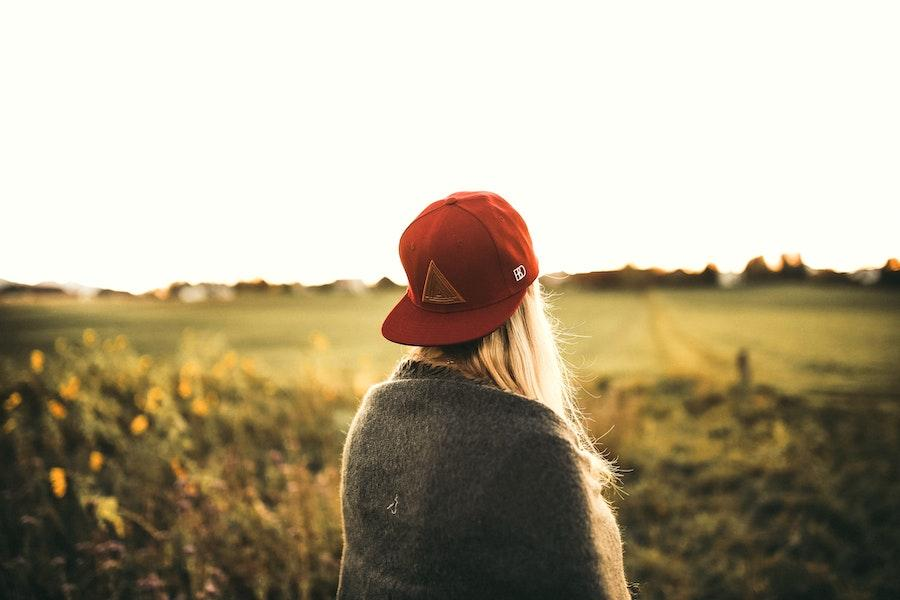 Woman wearing a red baseball hat facing backward